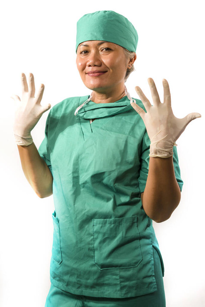 mature attractive and happy medicine doctor woman or hospital nurse in medical scrubs latex gloves and mask smiling confident isolated on white background - Fotó, kép