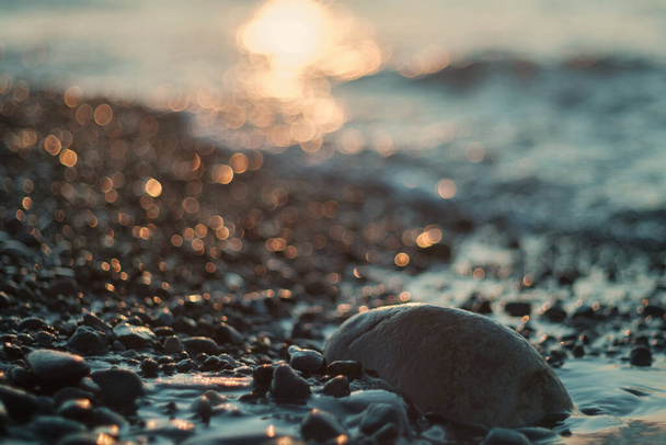 галечный пляж с размытым морем и солнцезащитным фоном, избирательный фокус
 - Фото, изображение