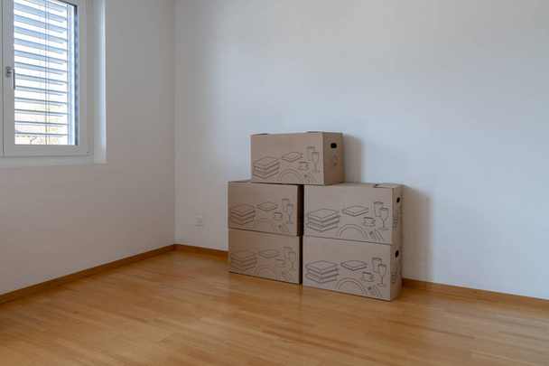 Vaakasuora näkymä suuri ruskea liikkuvat ja pakkaus laatikot tyhjä huoneisto
 - Valokuva, kuva