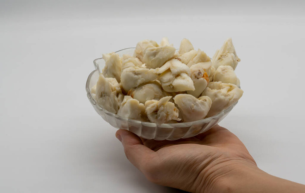 Servir à la main jumbo morceau de viande de crabe frais dans un bol en verre décoratif isolé sur fond blanc. Fruits de mer prêts à manger
. - Photo, image