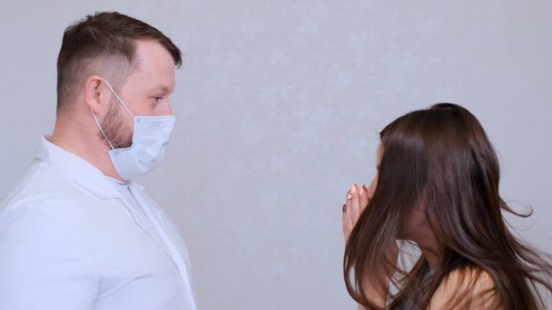 zieke vrouw heeft griep of verkoudheid en niest in aanwezigheid van een arts.  - Foto, afbeelding
