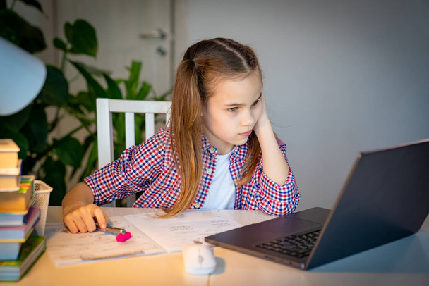 girl listens carefully online lesson on a notebook - Foto, Imagem