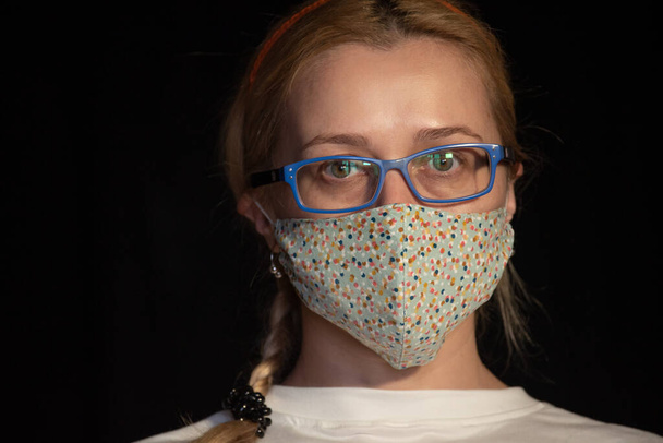 Coronavírus, mulher mascarada.Estúdio retrato de uma jovem mulher usando uma máscara facial, sobre fundo preto. Epidemia de gripe, alergia ao pó, vírus. Mulher mascarada num fundo preto. Coronavírus
 - Foto, Imagem