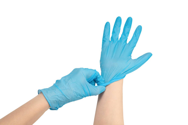 Woman puts on blue rubber gloves. Isolated on white. - Photo, Image