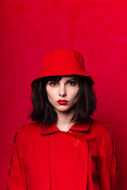 girl in red clothes with red lipstick on her lips, red background - Φωτογραφία, εικόνα