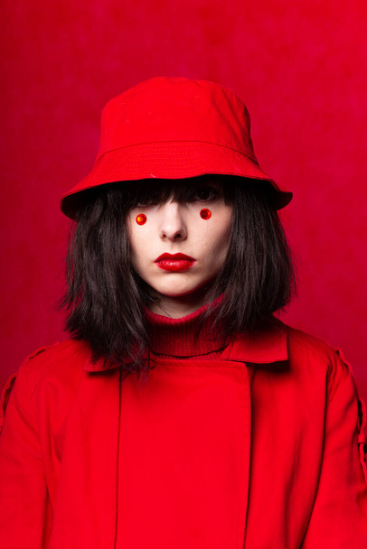a woman with a bob haircut, wearing a red trench coat - Foto, immagini