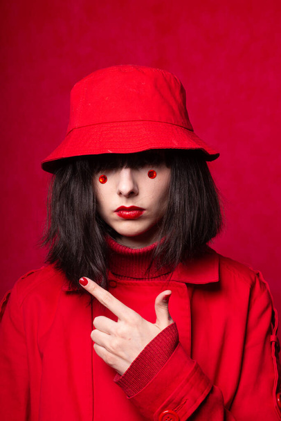 girl with red circles under the eyes, red background, red color - Фото, зображення