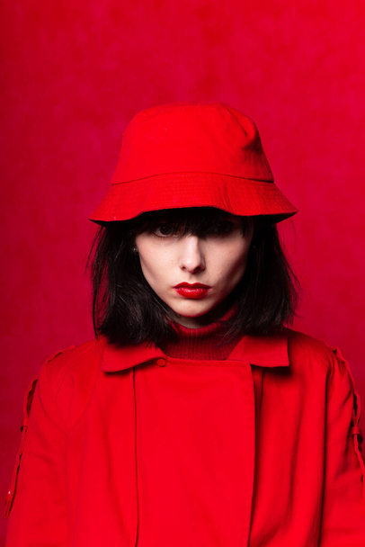 girl in a red trench coat on a red background - Fotografie, Obrázek