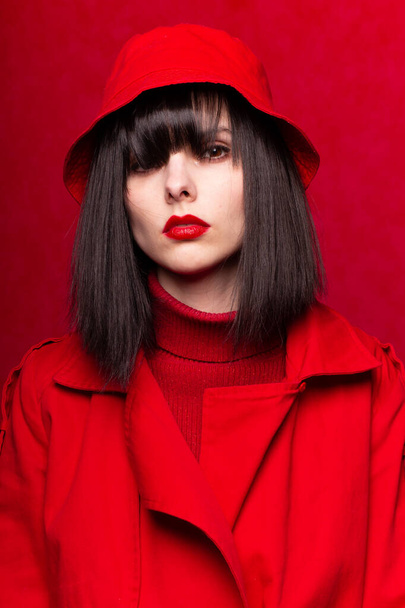 woman with bangs in red clothes, red background - Foto, immagini