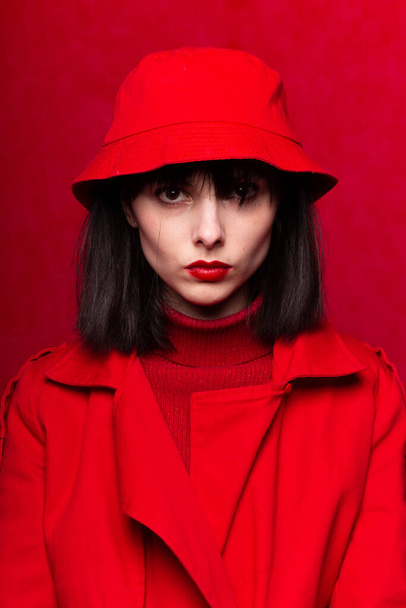 γυναίκα με αφέλειες σε κόκκινα ρούχα, κόκκινο φόντο - Φωτογραφία, εικόνα