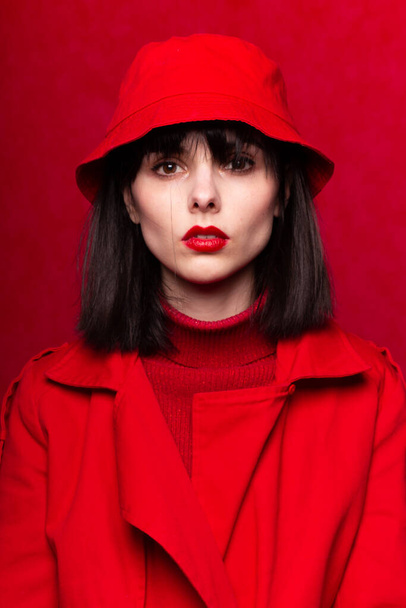 woman with bangs in red clothes, red background - Foto, Imagem