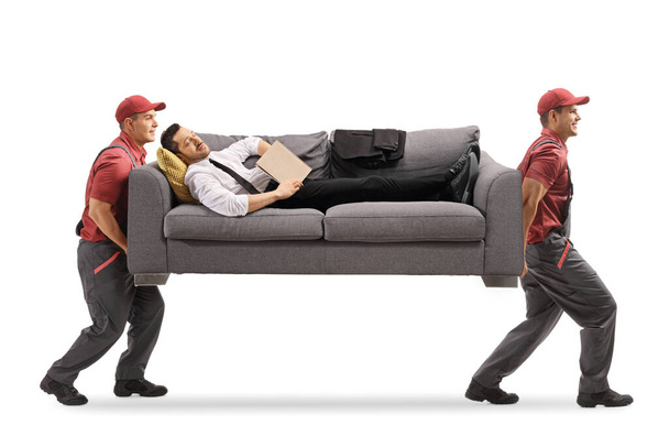 Empresario durmiendo en un sofá con un libro mientras se mueve llevando el sofá aislado sobre fondo blanco
 - Foto, imagen