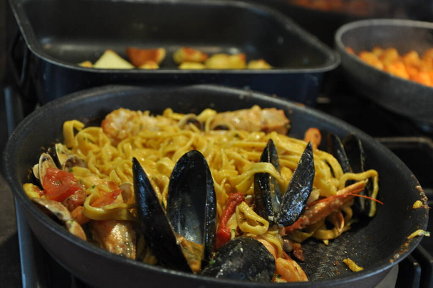 Špagety allo scoglio nebo špagety s mořskými plody podávané i s krevetami a dalšími mušlemi - Fotografie, Obrázek