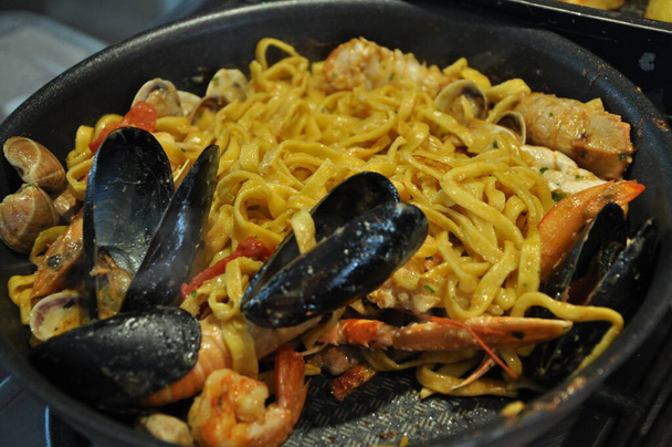 Špagety allo scoglio nebo špagety s mořskými plody podávané i s krevetami a dalšími mušlemi - Fotografie, Obrázek