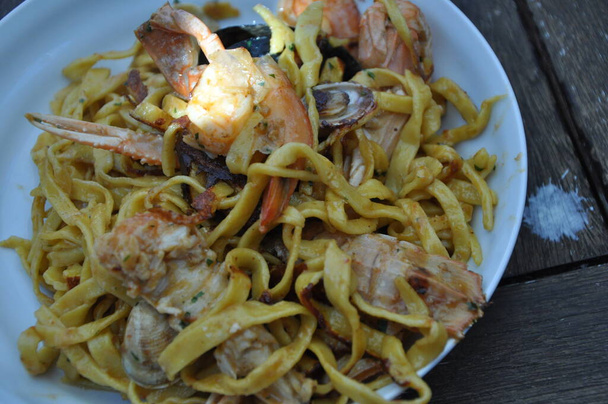Спагетті сплав скогліо або спагеті з морепродуктами, що подаються i з креветками та іншими мушлями
 - Фото, зображення