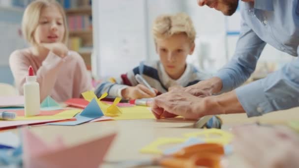 Elementary School Arts & Crafts Class: Enthusiastic Teacher, Diverse Group of Smart Children Have Fun together on Handicraft Project, Using Colorful Paper, Scissors and Glue to Create Fun Papier Mache - Filmagem, Vídeo