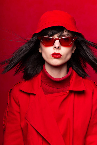 woman in red glasses on a red background - Foto, afbeelding