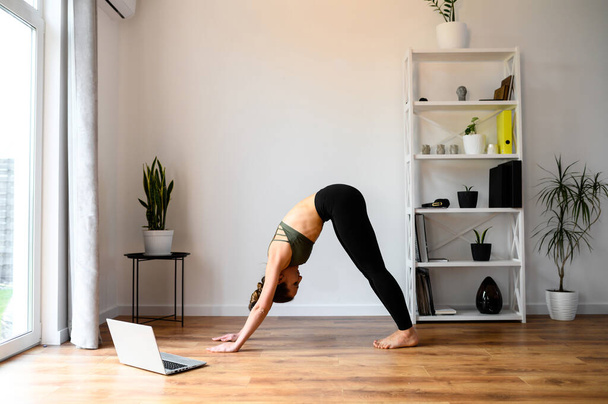 Woman is watching yoga tutorial video and repeats - Фото, зображення