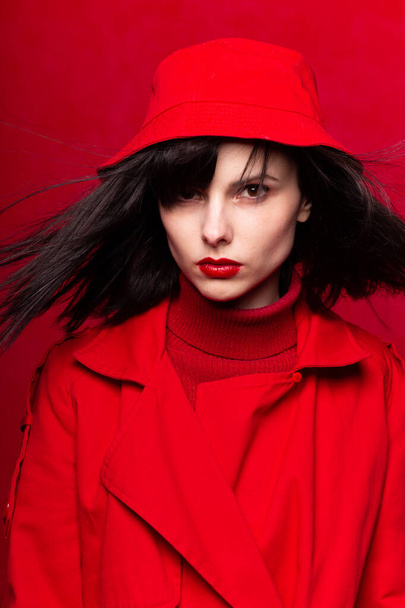 girl in red clothes, red background, red lips, the wind in her hair - Φωτογραφία, εικόνα