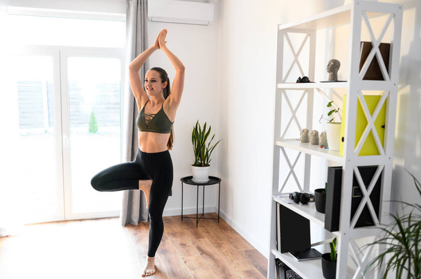 Jeune femme positive pratique le yoga à la maison
 - Photo, image