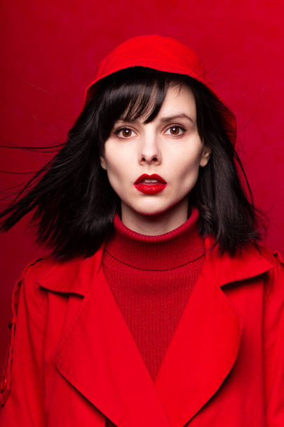 fatal woman in a red cloak, red background, red lipstick, flying hair - Foto, Imagem