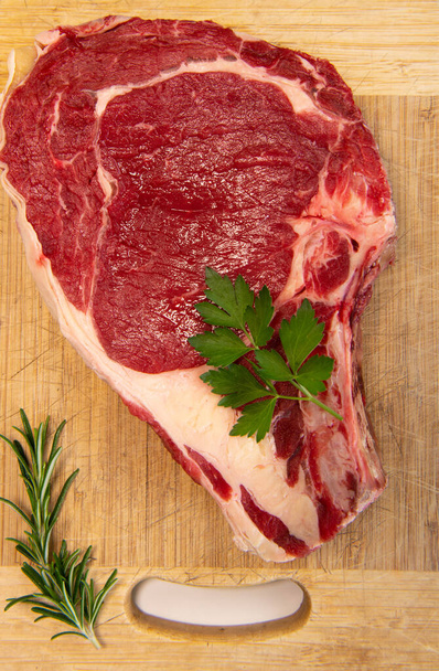 Raw T Bone steak on wooden board prepared to Grill  - 写真・画像