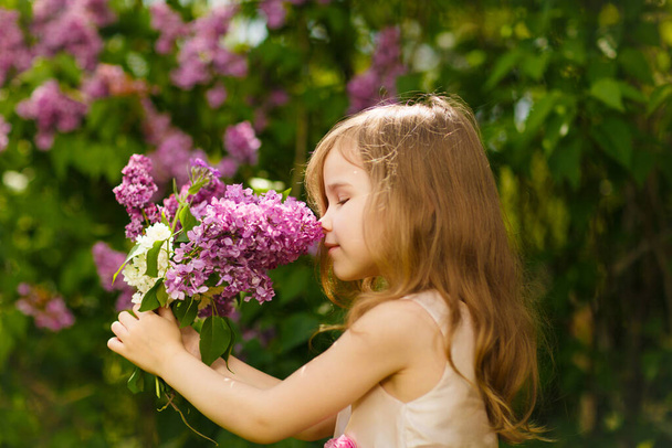 girl near lilac flowers snuff bouquet - Zdjęcie, obraz