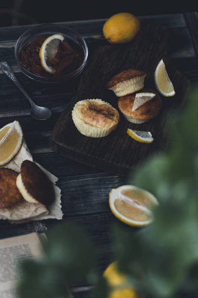 Frittelle di fiocchi di latte di limone su una tavola di legno con fette di limone su uno sfondo scuro. Cibo sano per la colazione del mattino. Posa piatta con spazio di copia. Orientamento verticale
. - Foto, immagini