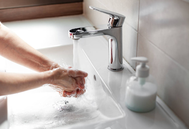 Hände mit Seife waschen, um eine Coronavirus-Infektion zu verhindern - Foto, Bild