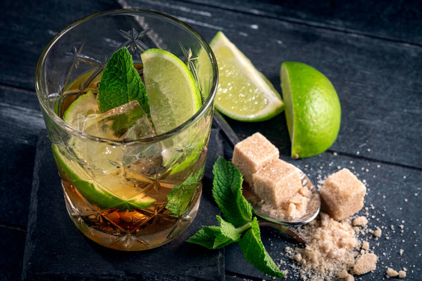 Cocktail con rum nero, lime e menta, bevanda alcolica brasiliana Caipirinha su legno scuro
 - Foto, immagini