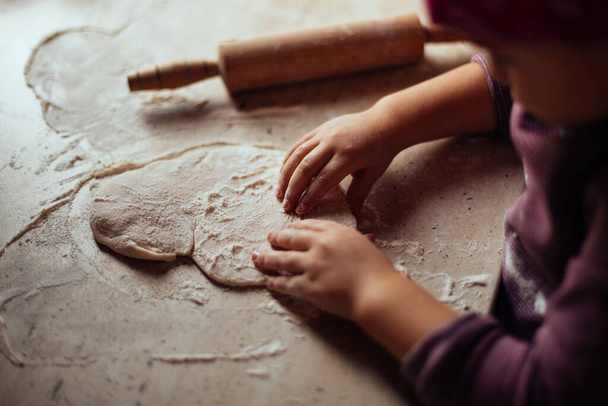 petites filles mains pétrissant la pâte sur la table
 - Photo, image