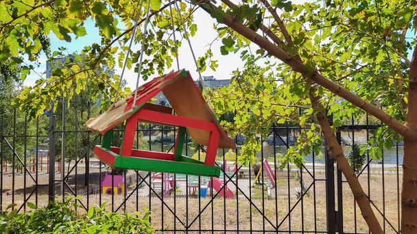 Alimentadores de aves hechos a mano de madera en un parque de la ciudad. Casa de aves
 - Foto, imagen