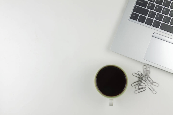 A coffee mug, a laptop, paperclips over the top on a white background - Foto, Imagem