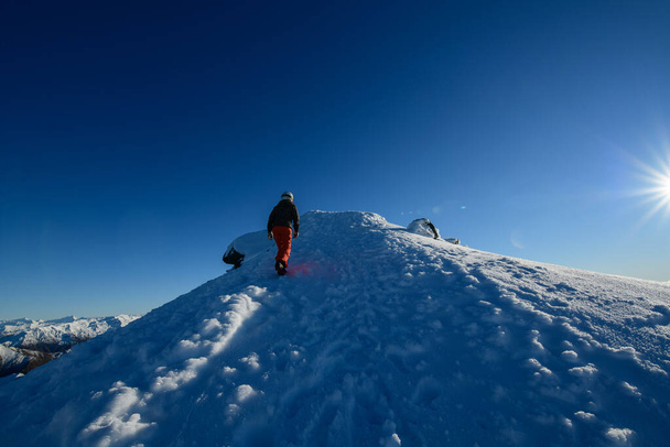 Utazók túrázás a tetején a hó hegy déli szigeten, Új-Zéland. - Fotó, kép