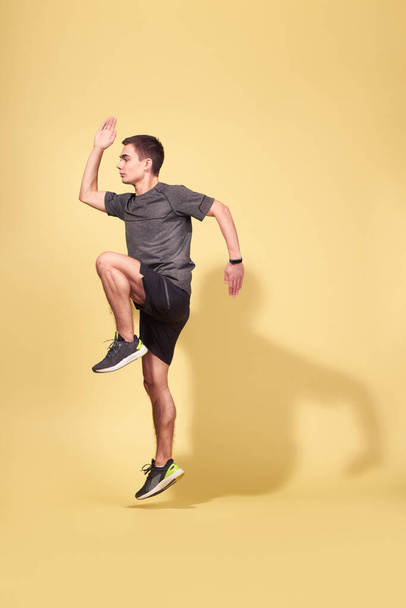 Side view of athlete man running in studio - Fotó, kép