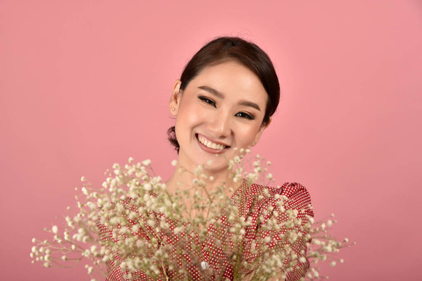 Asiatin entspannt auf rosa Hintergrund, Porträt einer glücklich lächelnden Frau mittleren Alters in lässiger Kleidung, die in die Kamera blickt. - Foto, Bild