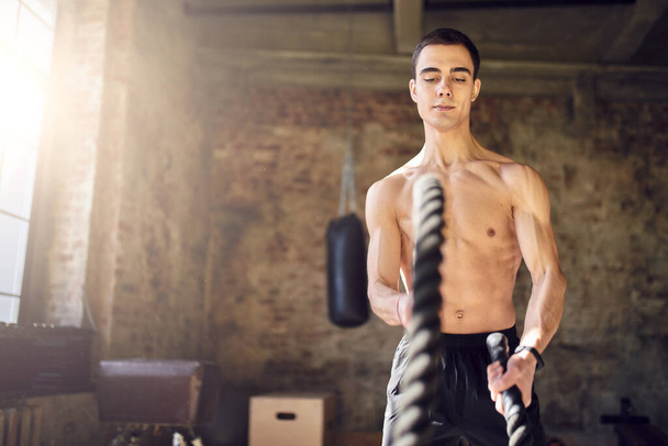 Sportsman with ropes against background of brick wall in gym - Φωτογραφία, εικόνα