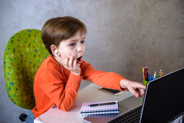 Children doing homework at home. The boys looks at the laptop. Back to school. Distance Learning Online Education. - Φωτογραφία, εικόνα