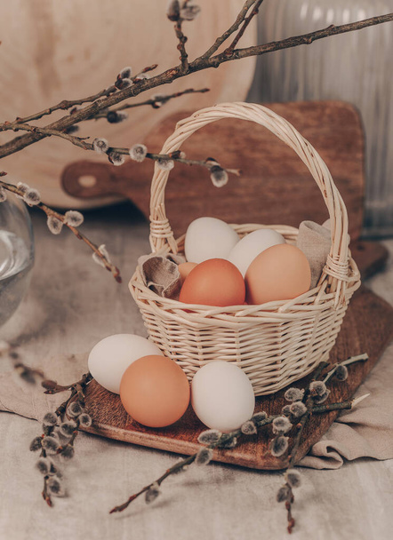 Easter eggs in basket and willow branches  - Фото, зображення