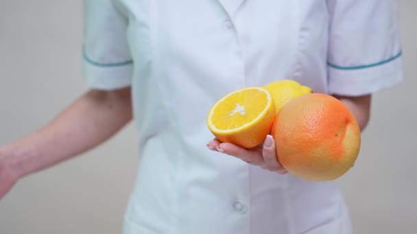 conceito de estilo de vida saudável médico nutricionista - segurando laranja, toranja e limão
 - Filmagem, Vídeo