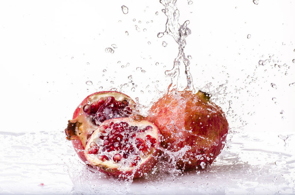 splash with fresh water on pomegranate isolated from the white background - Photo, Image