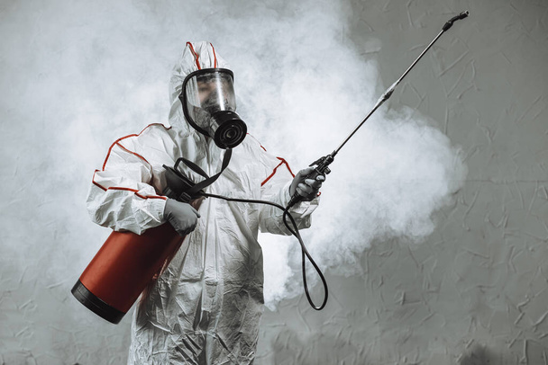 disinfector wearing protective biological suit and gas-mask conduct disinfection - 写真・画像