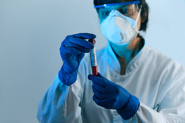 Coronavirus 2019-nCoV Blood Sample. Doctor scientist in protective gloves, mask and glasses holding test tube with blood for 2019-nCoV analyzing. Coronavirus blood test Concept. Vaccine research - Φωτογραφία, εικόνα