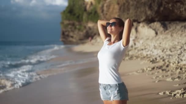 Mladá štíhlá krásná žena si užívá dovolenou na pláži oceánu, zpěněné vlny - Záběry, video
