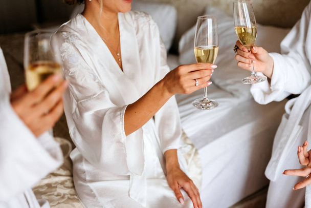 Lánybuli. Gyönyörű nők barátai visel pizsama szórakozás leánybúcsú esküvő előtt és pezsgő ivás  - Fotó, kép