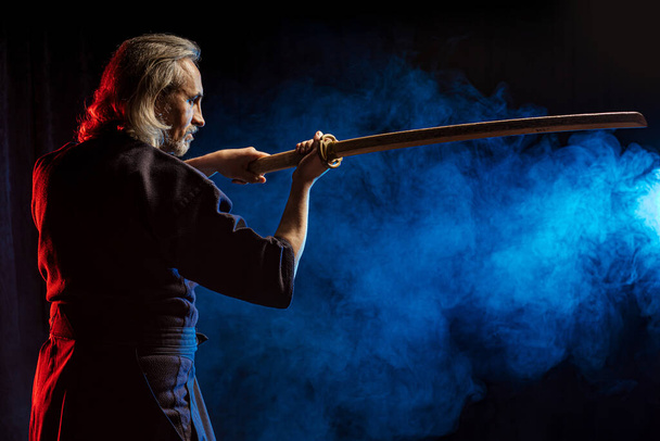side view on serious kendo fighter with shinai - Fotoğraf, Görsel