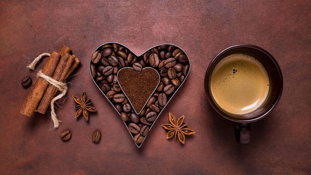 композиція з чашкою еспресо та силуетом у формі серця з кавовими зернами та меленою кавою
 - Фото, зображення