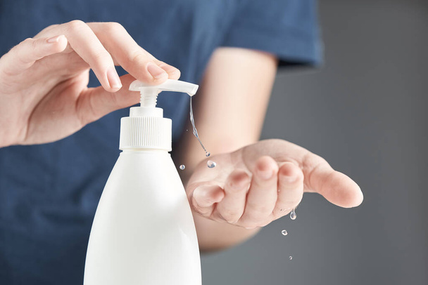 Female hands using hand sanitizer gel pump dispenser. Drops of gel close-up. - Valokuva, kuva