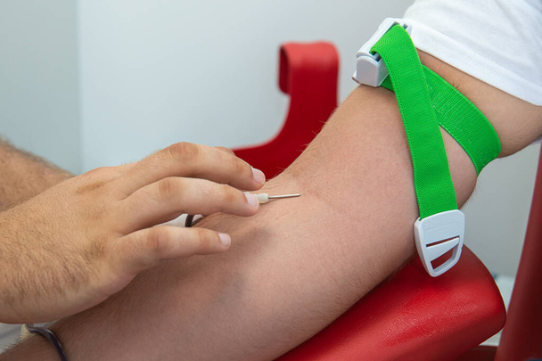 Blood donor at donation, transfusion. Insertion of a needle into a vein. - Photo, Image