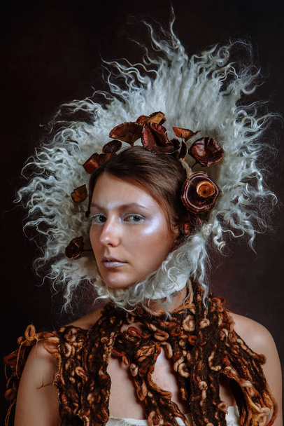 This girl is a parody of medieval princesses. A woman with a white felt ornament around her head - Foto, immagini